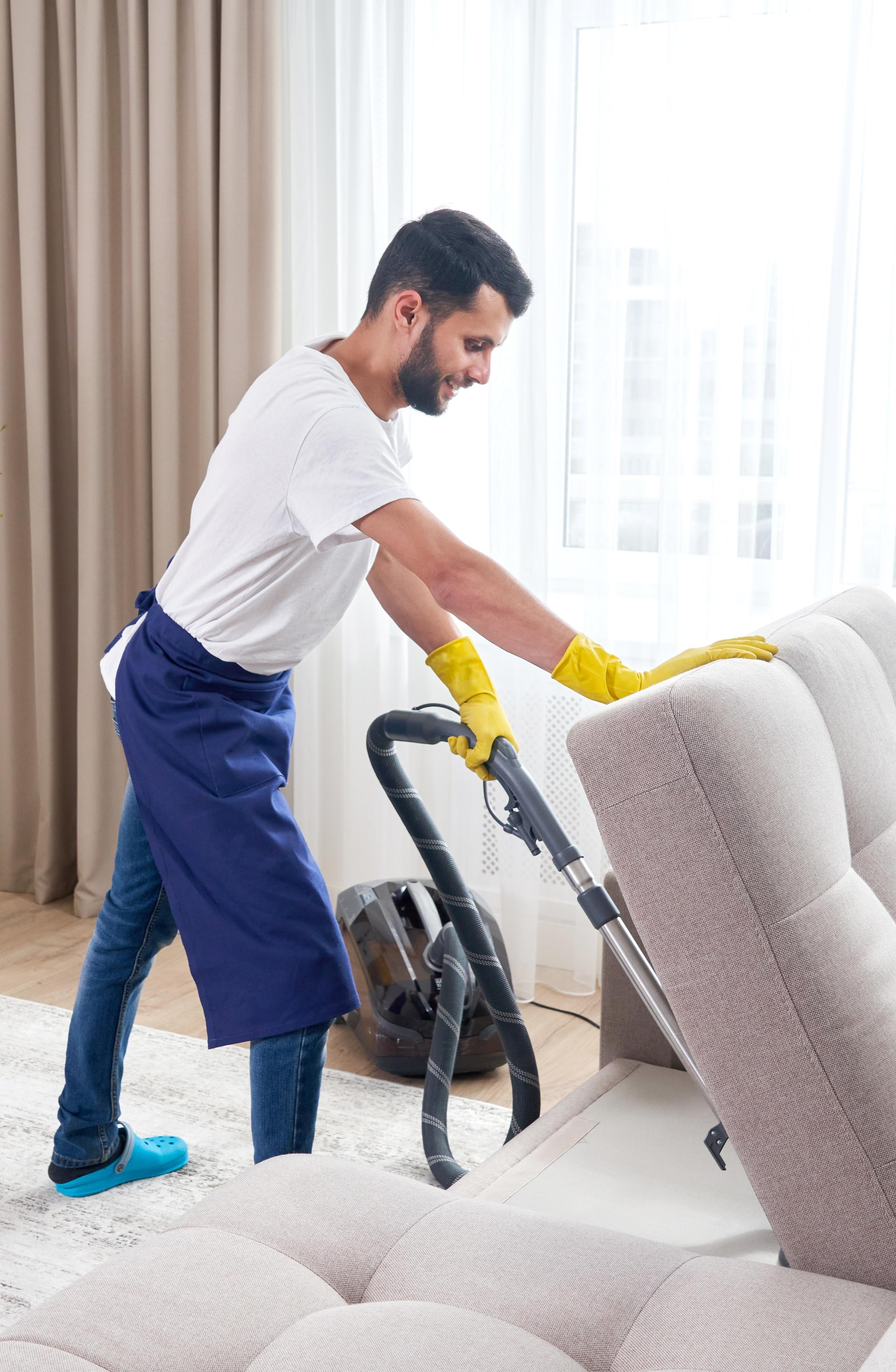 Vacuum cleaner on blue carpet with cleaning supplies